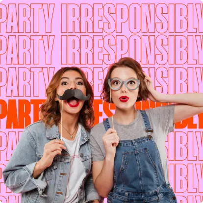 Two women in a photo booth with props on a pink background with wording that reads Party Irresponisibly